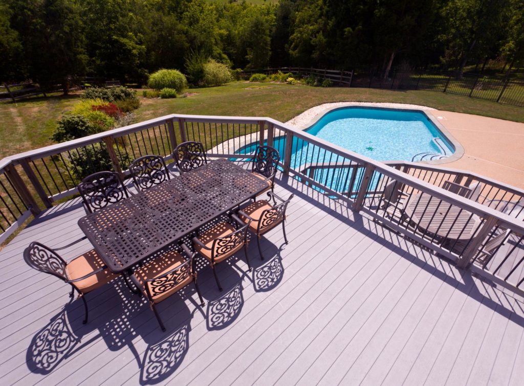 a pool deck with table and chairs